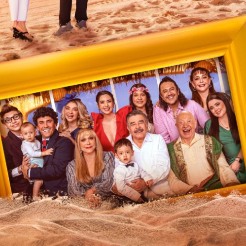 Cuadro fotográfico gigante con marco amarillo brillante colocado sobre la arena de una playa. Dentro del cuadro posa sonriente el elenco de la serie Una Familia de Diez vistiendo ropa veraniega y formal. Al centro destacan Jorge Ortiz de Pinedo, Eduardo Manzano y Zully Keith rodeados por Ricardo Margaleff, Daniela Luján, Andrea Torre, Mariana Botas, Moisés Iván Mora y los niños de la familia.