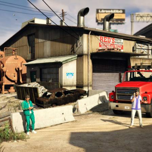 Imagen de dos personajes en un entorno industrial con un taller automotriz, maquinaria pesada y un camión de remolque, evocando la ambientación urbana característica de GTA Online.