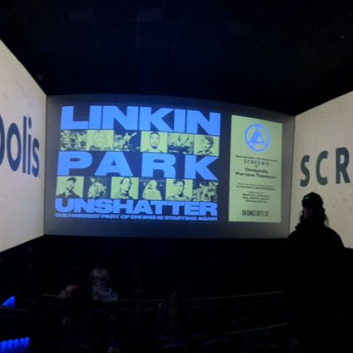 Fotografía del interior de la nueva sala ScreenX en Cinépolis Parque Tepeyac. En la pantalla frontal de gran formato se proyecta el cartel promocional del documental "Linkin Park: Unshatter" con gráficos en tonos azul y amarillo, mientras que en las paredes laterales extendidas se despliega en tipografía gigante la marca "Cinépolis" a la izquierda y "SCREENX" a la derecha, rodeando las butacas iluminadas en penumbra por luces LED azules.