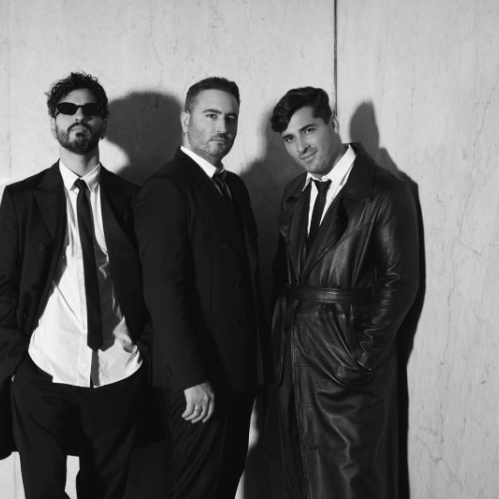 Reik, Jesús Navarro, Julio Ramírez y Bibi Marín del grupo Reik parados vistiendo elegantes trajes