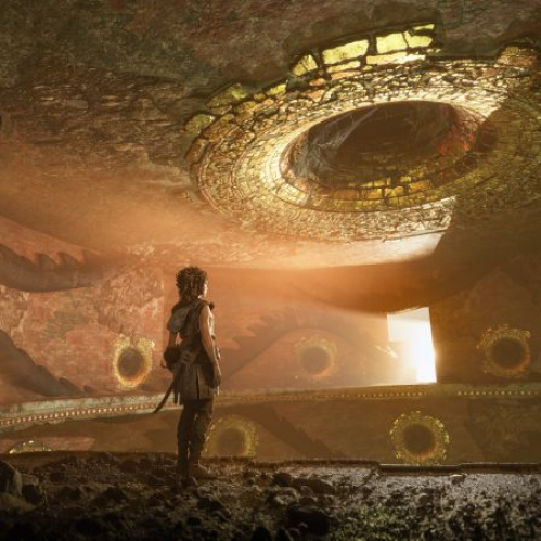 Personaje observando una estructura antigua iluminada por un haz de luz en un entorno cavernoso.