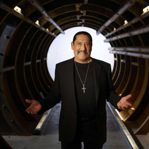 Persona de pie dentro de un túnel metálico iluminado, con un halo de luz al fondo y una atmósfera cinematográfica.