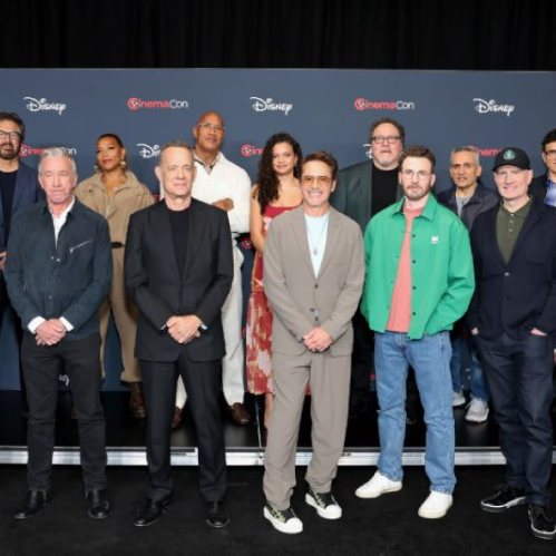 Grupo de talentos y ejecutivos posando frente a un fondo azul con logotipos de CinemaCon y Disney, en un evento oficial de presentación.