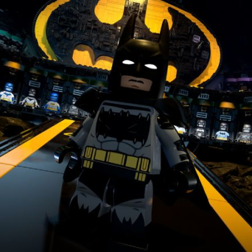 Figura de LEGO Batman en un entorno que representa la Baticueva, con vitrinas iluminadas que exhiben trajes y un símbolo del murciélago en el fondo.