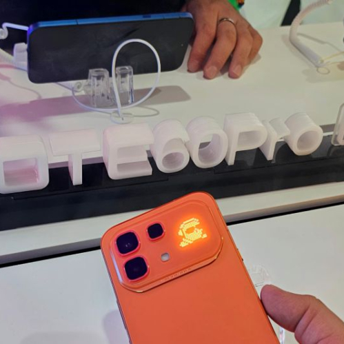 Smartphone en exhibición con iluminación distintiva junto a un letrero tridimensional del modelo NOTE 60 Pro 5G en un entorno de presentación tecnológica.