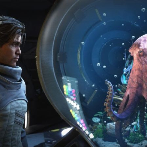 Captura en plano medio de una escena cinemática dentro de una nave espacial con iluminación tenue en tonos azules y metálicos. A la izquierda se observa a Jun, el protagonista humano vistiendo un traje táctico futurista gris con cuello alto y mirad fijamente a la derecha. Frente a él se encuentra un gran tanque acuático de cristal circular donde habita Salt, un pulpo de tono morado que flota cerca del vidrio apoyando sus tentáculos mientras mira hacia el personaje.