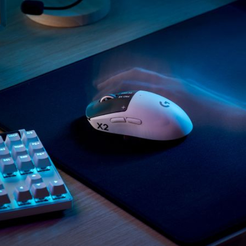 Mouse y teclado de gaming sobre un escritorio de madera, con iluminación fría y un diseño orientado al rendimiento competitivo.