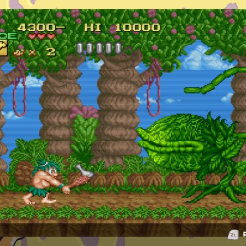Captura de pantalla de jugabilidad (gameplay) en formato retro de "Joe & Mac Retro Collection". En el centro se observa a Joe en un escenario de selva prehistórica atacando a una planta carnívora gigante con un garrote de madera. La pantalla cuenta con un marco ilustrado con estilo de arte retro que incluye dinosaurios, cavernícolas y un pterodáctilo, además de mostrar los controles de pausas y rebobinado (rewind) en la barra inferior.