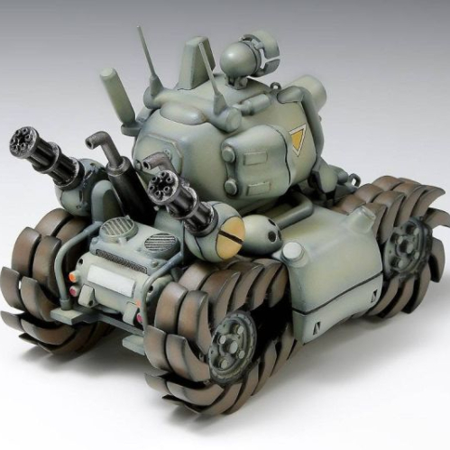 Fotografía de estudio del modelo a escala 1/24 del tanque SV-001 de Metal Slug sobre un fondo blanco. El vehículo de color verde caqui y grandes orugas cafés muestra un diseño compacto con dos torretas de ametralladoras frontales, cañón posterior, antena y escape detallados.