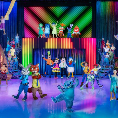 Elenco completo de personajes de Disney reunido en un escenario multicolor sobre hielo durante una rutina grupal.