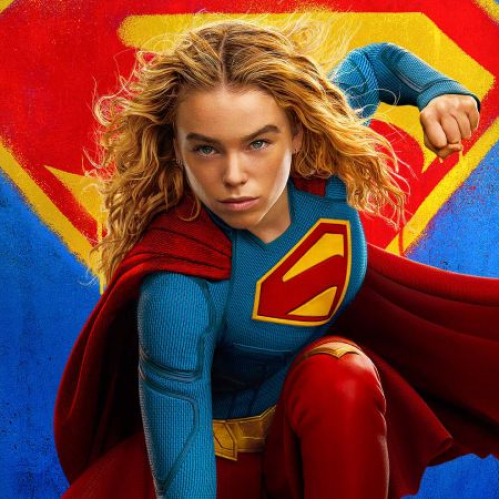 Póster promocional centrado en Kara Zor-El / Supergirl (Milly Alcock) vistiendo el traje azul clásico con capa roja y el emblemático símbolo de la 'S' pintado estilo grafiti en amarillo y rojo sobre un fondo azul texturizado.