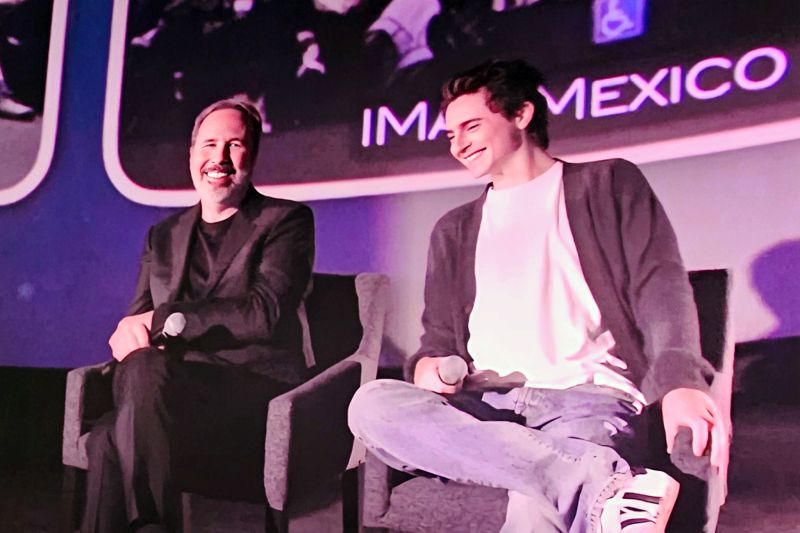 Dos integrantes del equipo creativo conversan en un escenario durante una presentación vinculada a IMAX México.