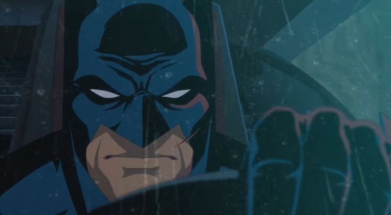 Batman: Knightfall – Tráiler oficial Figura enmascarada dentro de un vehículo en un entorno oscuro con iluminación tenue.