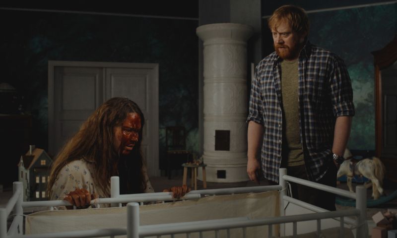 Engendro — Quiebre emocional Dos personas en una habitación oscura junto a una cuna, con tensión evidente en la escena.
