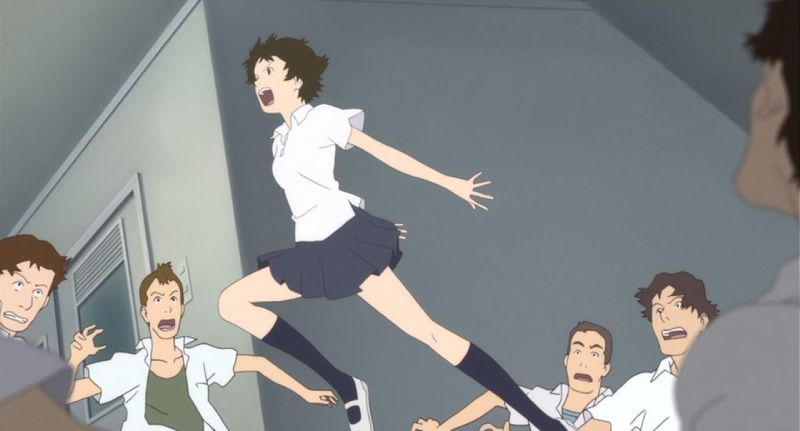 Fotograma del filme donde Makoto Konno realiza un salto acrobático en un aula mientras sus compañeros observan con expresiones de sorpresa.