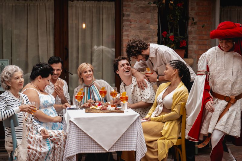 Grupo reunido alrededor de una mesa con comida y bebidas.