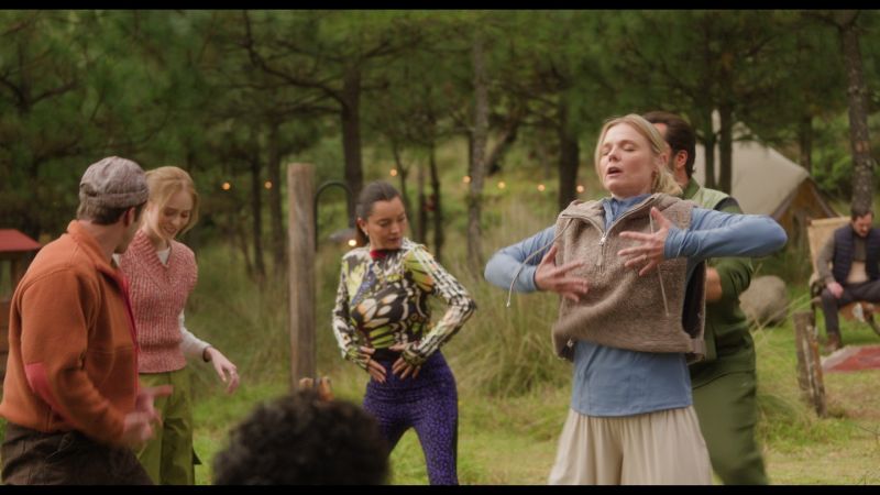 Dinámica de Integración Familiar Grupo de personas realizando una dinámica de movimiento expresivo en círculo al aire libre rodeados de árboles.