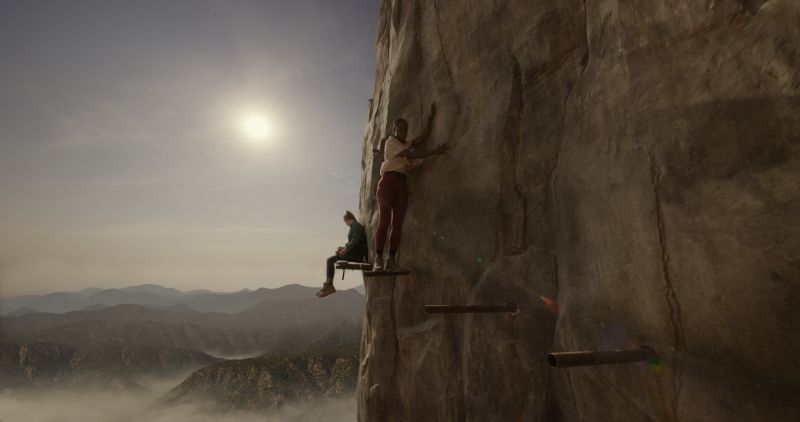 Descanso en las plataformas de la montaña Dos personas descansando en estrechas plataformas metálicas fijadas a la pared del acantilado al atardecer.