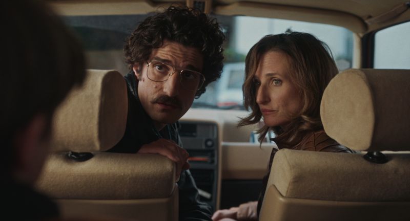 Escena dramática entre los padres dentro del auto familiar Los padres de Vincent interpretados por Louis Garrel y Camille Cottin mirando atentos hacia el asiento trasero del automóvil con expresiones de seriedad y preocupación.