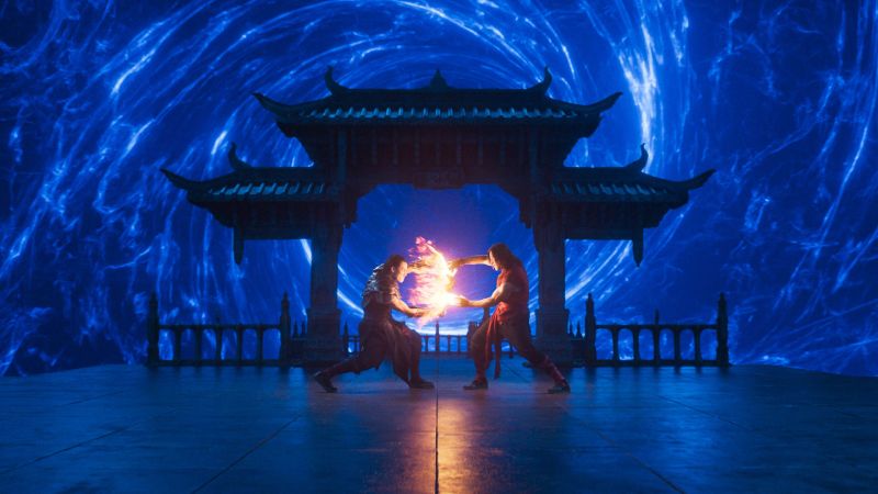 Mortal Kombat II — Duelo elemental Dos combatientes canalizan energía luminosa frente a una estructura tradicional.