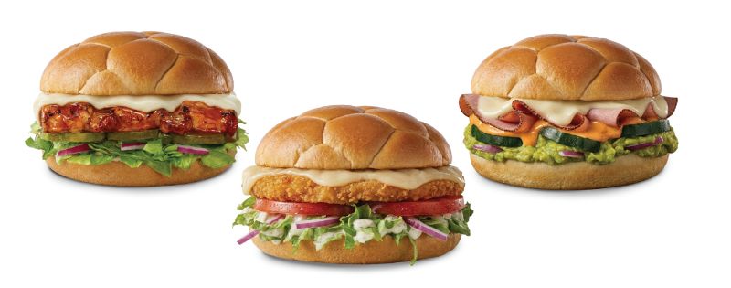 Sándwiches Golazo de Subway en menú permanente para México Fotografía publicitaria sobre fondo blanco de los tres sándwiches "Golazo" de Subway, preparados en pan redondo con textura esculpida de balón de fútbol. De izquierda a derecha se muestran las versiones de Costillitas BBQ, Milanesa de Pollo y Jamón y Queso con Guacamole con sus respectivos ingredientes visibles.