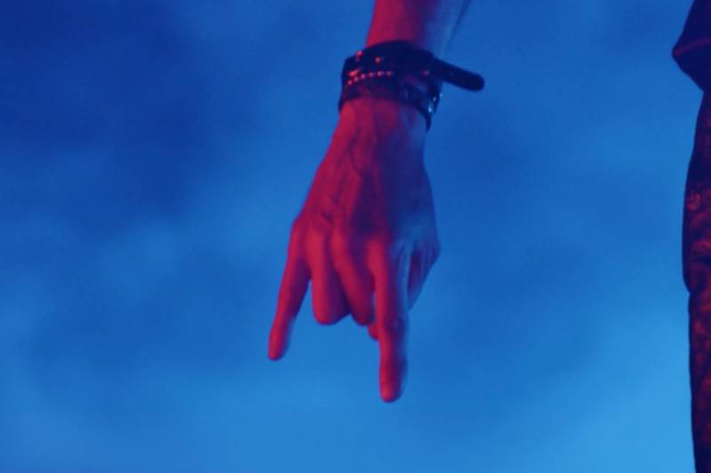 Arte promocional de Sigo atravesando puertas Primer plano de un brazo extendido hacia abajo sobre un fondo azul, acompañado del nombre de la banda y el título del lanzamiento.