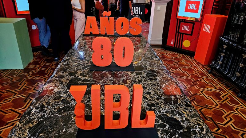 Instalación con letras volumétricas naranjas y elementos decorativos alusivos a un evento temático.