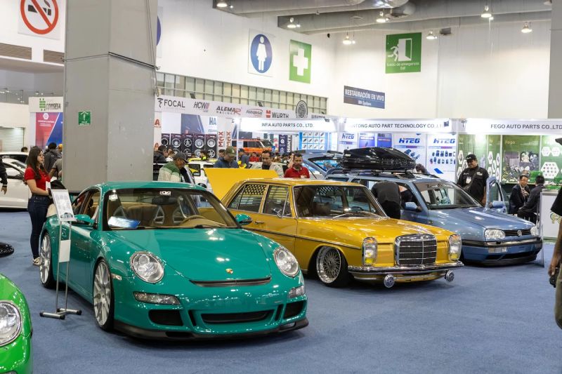 Exhibición de vehículos en INA PAACE Automechanika 2026 Fotografía del piso de exposición de INA PAACE Automechanika mostrando autos clásicos y deportivos modificados alineados, rodeados por estands de fabricantes de autopartes y asistentes.