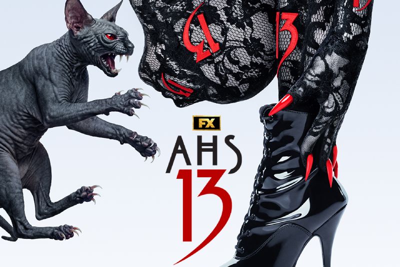 Póster oficial de American Horror Story 13 para Disney Plus Afiche promocional sobre fondo blanco para la serie American Horror Story: 13. A la izquierda, un gato esfinge (Sphynx) de piel oscura, ojos rojos brillantes y garras afiladas aparece saltando. A la derecha se aprecia la pierna de una mujer vestida con mallas de encaje negro, uñas largas teñidas de rojo intenso y una bota negra de tacon alto acordonada. En el centro destaca el logotipo oficial de FX y el título "AHS 13" en letras negras y rojo fuego.