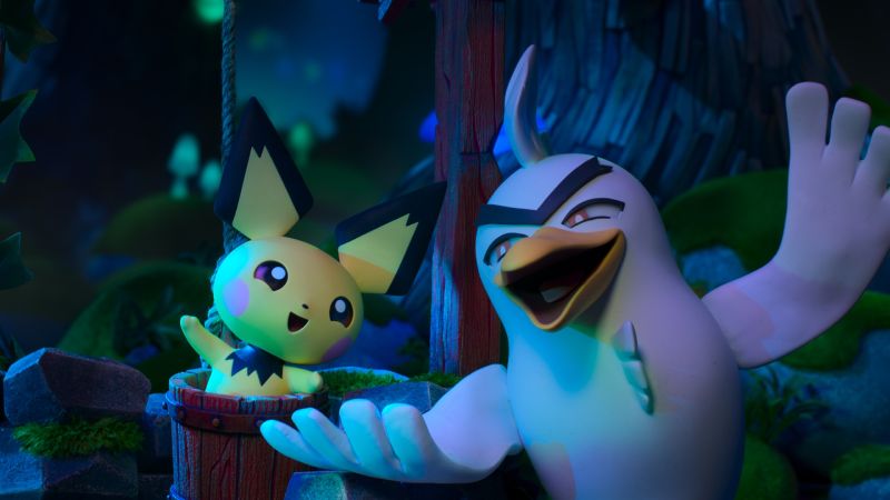 Sirfetchd y Pichu en la serie stop-motion Historias Pokemon de Aardman y Disney Plus Fotografía promocional en animación stop-motion ambientada en un entorno nocturno de vegetación. A la izquierda, un Pichu de color amarillo con orejas negras se asoma sonriendo desde el interior de un cubo de madera levantando su pata derecha. A su lado, un Sirfetch'd de plumaje blanco y pico amarillo extiende sus alas en un gesto expresivo y sonriente mirando al frente.