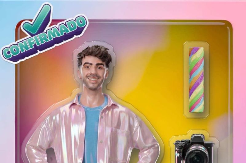 Fede Vigevani confirmado como doceavo habitante de "La Casa de los Famosos México" Imagen promocional oficial de confirmación para "La Casa de los Famosos México". Al centro aparece Fede Vigevani, un joven de tez clara con cabello castaño corto y ondulado, sonriendo a la cámara y vistiendo una playera azul bajo una camisa o chamarra rosa brillante con acabado metálico o iridiscente. En la esquina superior izquierda destaca un logotipo con la palabra "CONFIRMADO" en letras verdes dentro de un contorno blanco y con un icono de palomita. A la derecha del personaje, flotando sobre un fondo degradado entre tonos cálidos de amarillo y rosa, se aprecian recortes en el empaque que muestran un dulce cilíndrico multicolor y una cámara fotográfica profesional de color negro.