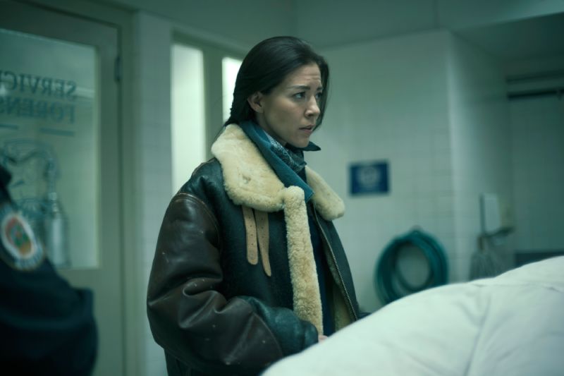 Fernanda Castillo en "Prefiero la muerte" Fernanda Castillo con chaqueta militar de piel mirando con preocupación en una sala de morgue o servicio forense.