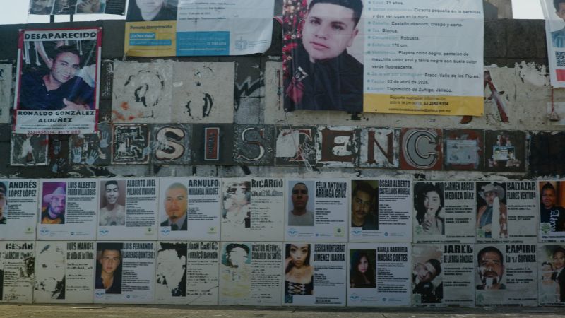 Muro con la palabra RESISTENCIA y múltiples boletines de búsqueda de personas desaparecidas pegados en la pared.