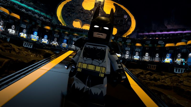 LEGO Batman: El Legado del Caballero de la Noche – Baticueva Figura de LEGO Batman en un entorno que representa la Baticueva, con vitrinas iluminadas que exhiben trajes y un símbolo del murciélago en el fondo.