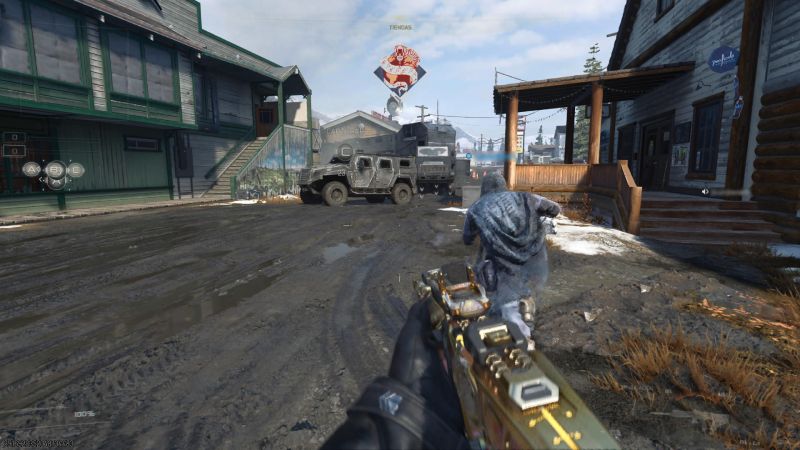 Vista en primera persona con un arma dorada en un pueblo nevado mientras un operador corre al frente.