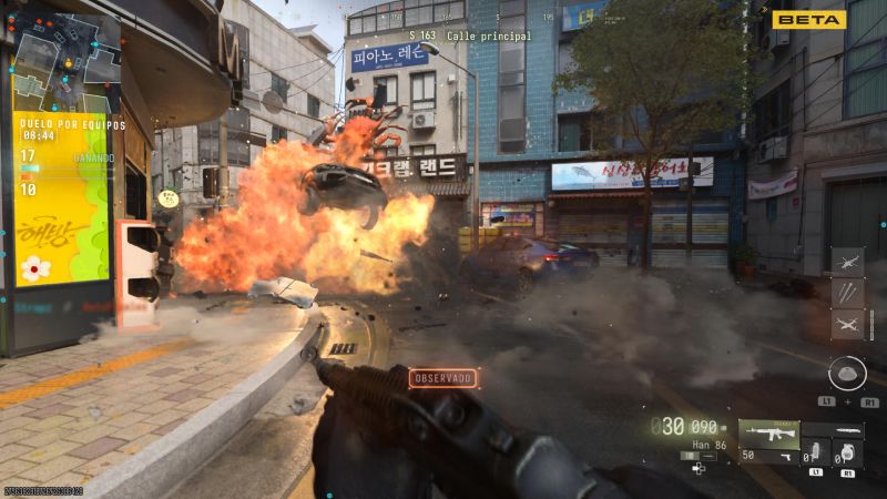 Captura de pantalla de combate multijugador en primera persona en una calle urbana de Corea del Sur con una gran explosión de automóvil frente al jugador.