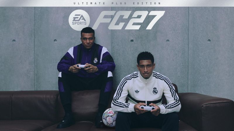 Portada oficial de EA SPORTS FC 27 Ultimate Plus Edition con Mbappé y Bellingham Imagen de portada oficial de EA SPORTS FC 27 Ultimate Plus Edition. En la parte superior sobre un fondo de pared de concreto gris aparece el logotipo de EA SPORTS FC 27 en letras blancas. En el centro, Kylian Mbappé y Jude Bellingham, futbolistas del Real Madrid, posan sentados en un sofá de piel marrón oscuro. Mbappé vista un conjunto deportivo de entrenamiento del Real Madrid color morado con negro y sostiene un control de consola blanco en las manos. A su lado, Jude Bellingham porta una chaqueta deportiva Adidas del Real Madrid en color blanco con franjas negras y sostiene otro control blanco. A sus pies descansa un balón de fútbol oficial de la UEFA Champions League sobre la alfombra.
