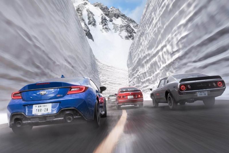 Tres vehículos avanzan por un paso montañoso flanqueado por altos muros de nieve.