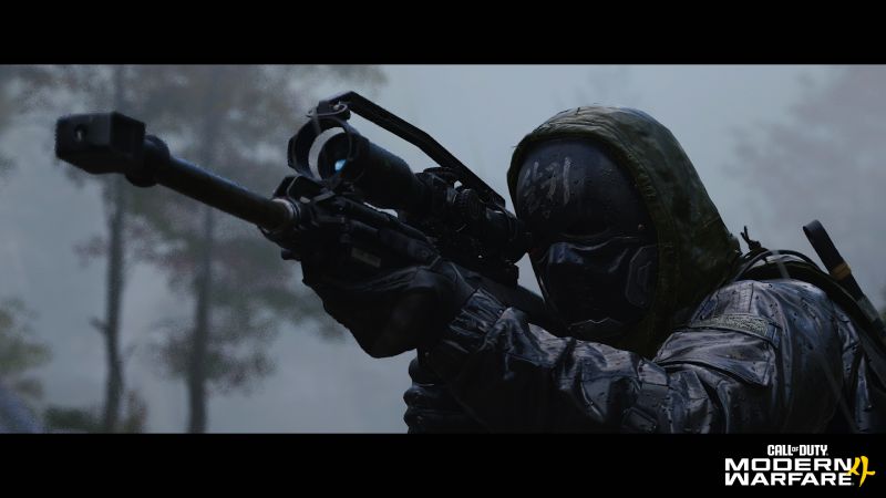 Call of Duty Modern Warfare 4 PC Requisitos Un operador militar con capucha negra, máscara táctica con caracteres orientales grabados en la frente y guantes tácticos apunta detenidamente un fusil de precisión con mira telescópica en medio de un bosque lluvioso con el logotipo oficial de Call of Duty Modern Warfare 4 en la esquina inferior derecha.